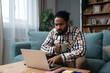 © Srdjan - Young freelance business man or exchange student working remotely from his home office on laptop computer, having issue with internet connection or web page. Nervous African American work problems