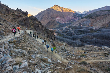 Group of people with big backpacks hiking on Mount Toubkal, Moroccow