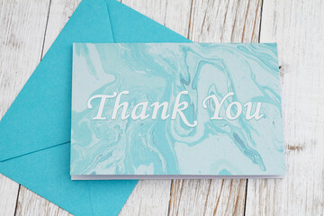 Wall Mural - Thank you greeting card with blue envelope and on wood