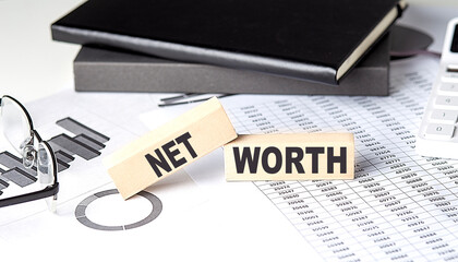Poster - NET WORTH - text on a wooden block with chart and notebook