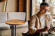© Drobot Dean - Portrait of smiling man using tablet while sitting in cafe