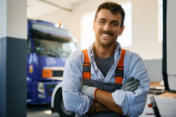 Wall Mural - Happy mechanic at truck repair shop looking at camera.