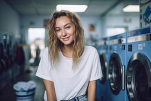 Young Woman Enjoying Clean Ironed Clothes In The Self Serviced Laundry With Dryer Machines On The Background