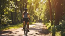 Experience The Joy Of Biking And Staying Fit With A Woman In The Park, As She Trains And Improves Her Cardiovascular Health. Enjoy The Outdoors And The Thrill Of Exploration As She Rides Her Bike
