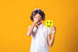 Upset girl holds happy emoticon. Stress and psychology concept