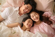 © Ahmed - Happy Asian family lying on bed in bedroom with happy and smile, top view