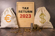 Tax text in wooden cubes and tax or vat form documents to complete Individual income tax return