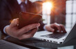 © Katsiaryna - business man hands busy using cell phone at office desk