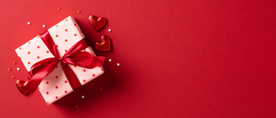 Wall Mural - Valentine's day gift. Banner design with present box and hearts on red background.