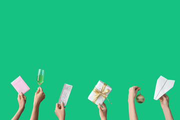 Wall Mural - Female hands holding passport with ticket, paper plane and gift on green background. New year vacation concept