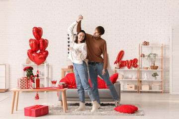 Wall Mural - Young couple dancing at home. Valentine's day celebration