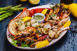 Seafood platter. Grilled lobster, shrimps, scallops, langoustines, octopus, squid on white plate.