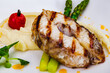 Grilled fish with mashed potatoes and asparagus on white plate
