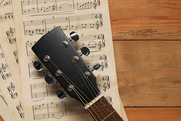 Sticker - Paper sheets with music notes and acoustic guitar on wooden table, top view