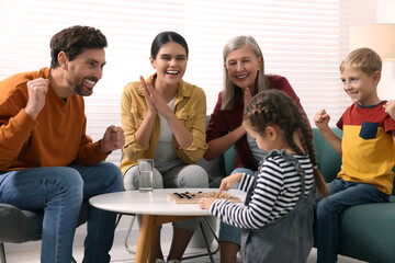 Sticker - Family playing checkers at coffee table in room