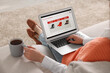 © New Africa - Woman with cup of tea shopping online during sale on laptop at home, closeup