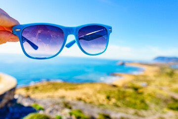 Wall Mural - Sunglasses against sea coast