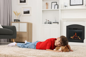 Poster - Little boy with cute ginger cat on soft carpet at home