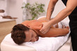 © New Africa - Man receiving professional back massage on couch in spa salon