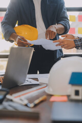 A team of construction engineers talks to managers and construction workers at the construction site. Quality inspection, work plan, home and industrial building design project