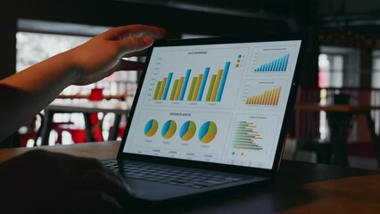 The IT programmer opens the laptop screen with statistics displayed on the display in the form of graphs. A close-up of a laptop display with statistics opens in a dark room. High quality 4k footage