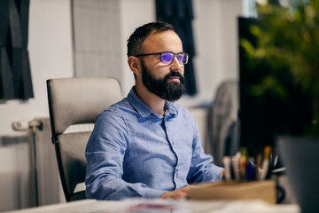 Wall Mural - A businessman is sitting at office and working on a computer.