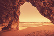 © vvvita - Rocky seascape in the evening. View of the sea from the cave. A golden sunset on the beach. Adraga beach, Lisbon region, Portugal