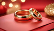 Wedding rings on red envelope with bokeh background.