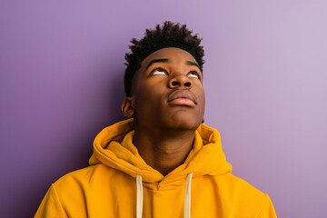 Wall Mural - African American serious teenage boy wearing hoodie on purple background