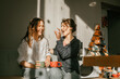 © Irina_Evva - Cozy morning: girls friends talking over a cup of coffee in a bright kitchen Two women spend time peacefully on a sunny day with mugs of tea