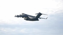 C-17 Military Cargo Plane Flying with Bright Sky Background