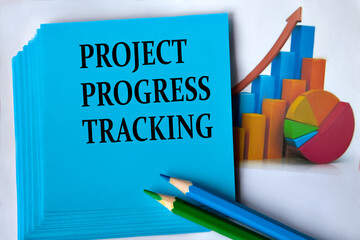 PROJECT PROGRESS TRACKING - words on a blue sheet of paper with pencils on the background of graphics