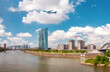 Airplane flying over the european city skyline and financial centre of Frankfurt am Main. Skyscraper buildings in Germany on sunset background. Business and finance concept