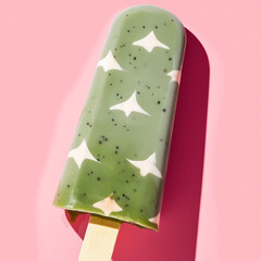 Wall Mural - Green popsicle with star patterns on a pink background. The vibrant and whimsical scene highlights creative and modern dessert artistry.