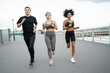 © muse studio - Three friends jog together on a promenade, sharing a dynamic workout.