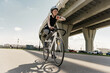 © muse studio - Urban cyclist in sportswear enjoying a bike ride under a sunny sky.