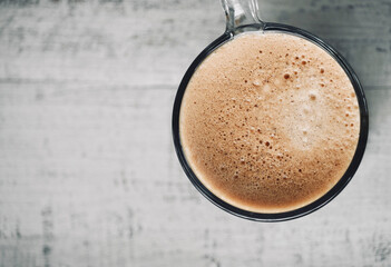 Top view foam coffee mug on white wooden table top with space for text.