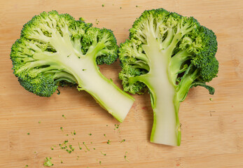 Two halves of fresh green broccoli on a wooden board. An appetizing vegetable for a healthy diet.