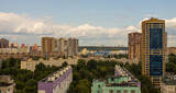 Fototapeta Miasto - A residential area with modern multi-storey buildings among green trees in Reutov, Moscow region on a sunny summer day and a space for copying