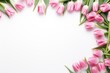 Spring composition as frame of pink tulips around on white background. Greeting card with copy space.