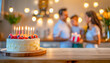 Tort urodzinowy ze świeczkami na drewnianym blacie. W tle rodzice dający dziecku prezent urodzinowy