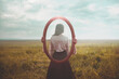 © Cristina Conti - woman holding a mirror who is mirrored appears from behind, identity concept