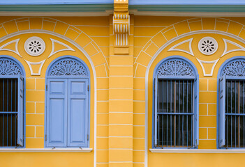 Wall Mural - Row of blue wooden arch windows on vintage yellow building wall background, exterior architecture in street minimal style