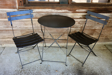 bistro table with two chairs on the sidewalk