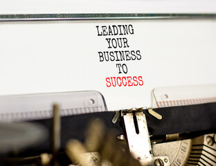 Wall Mural - Leading your business to success symbol. Concept words Leading your business to success typed on old retro typewriter. Beautiful white background. Leading your business to success concept. Copy space