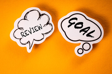 Wall Mural - Review and Goal Concept. Speech bubbles on a yellow background