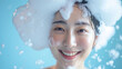 Beautiful Korean woman with a dollop of shampoo foam on her head