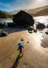 A Child Walks Over The Sand At Muir Beach Near San Francisco With Foggy Mountains In The Background