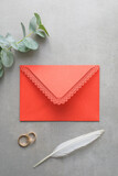Fototapeta Tulipany - Wedding background, red invitation envelope on gray background, top view