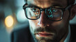 portrait of a pensive and worried bearded businessman with a reflection of a computer screen in his glasses